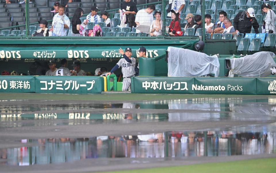 　水浸しのグラウンドを見つめる敦賀気比ナイン＝甲子園