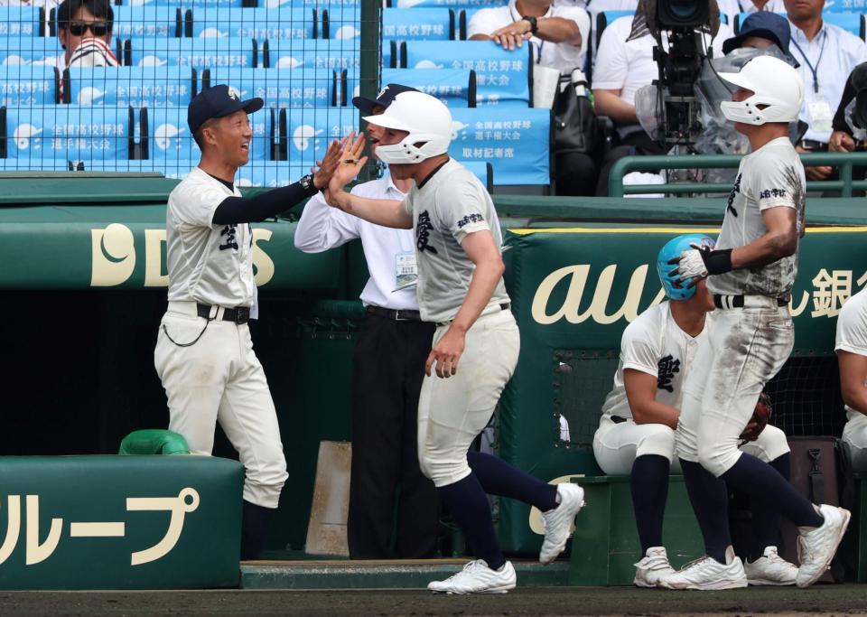 　４回、沢田蓮の同点２点適時打で生還した走者を迎える弘前学院聖愛・原田一範監督（左）＝撮影・中田匡峻