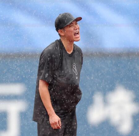 　激しい雨が降る中、グラブをシャツの中に隠してノックを受ける坂本（撮影・西岡正）