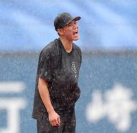 　激しい雨が降る中、グラブをシャツの中に隠してノックを受ける坂本（撮影・西岡正）