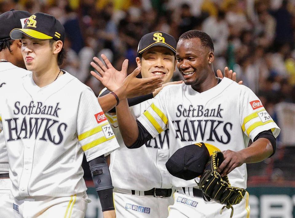 　完封で１０勝目を挙げ、ナインとタッチを交わすモイネロ（右）