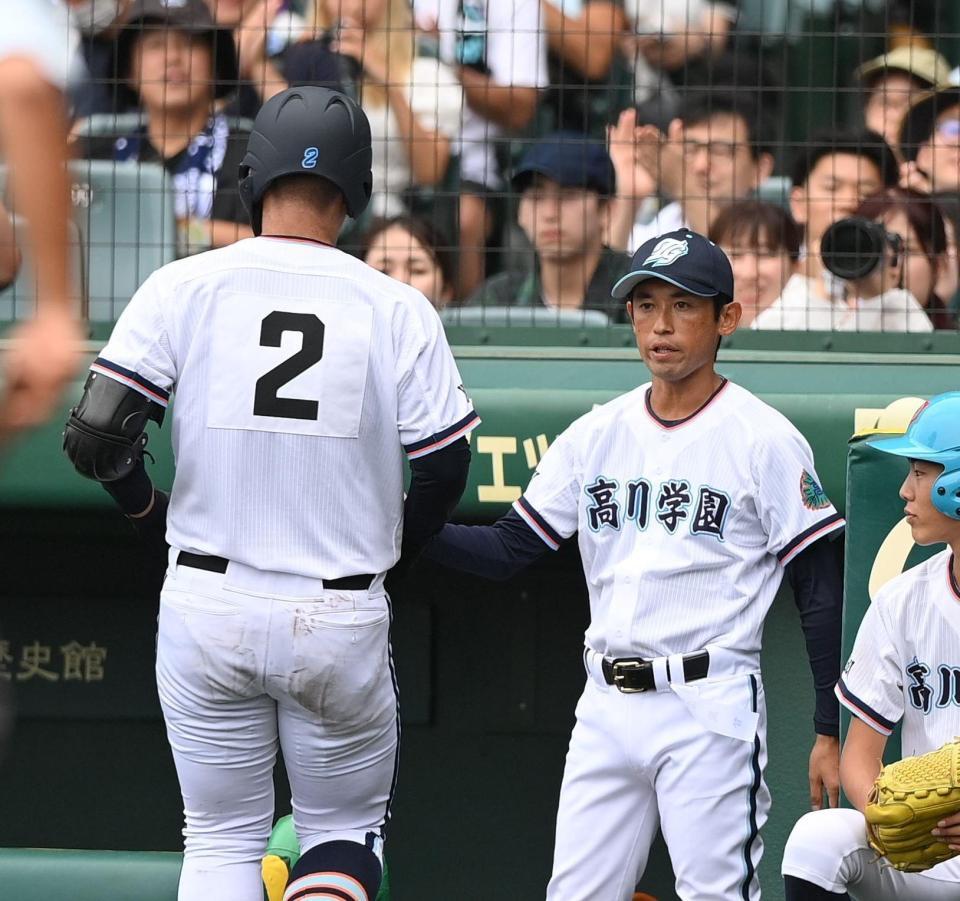 　２回、ソロを放った遠矢文太（左）を迎える高川学園・松本祐一郎監督（撮影・西田忠信）