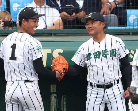 　８回のピンチをしのいだ桑山皓太朗（左）とタッチを交わす津田学園・佐川竜朗監督（撮影・中田匡峻）
