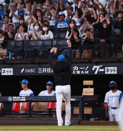 　２回、プロ初安打を放った有薗の記念球をスタンドのファンに掲げる新庄監督（撮影・中島達哉）