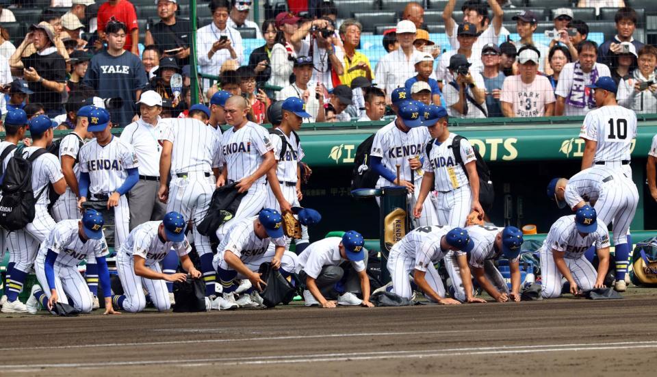 　グランウンドの土を拾う健大高崎ナイン（撮影・山口登）