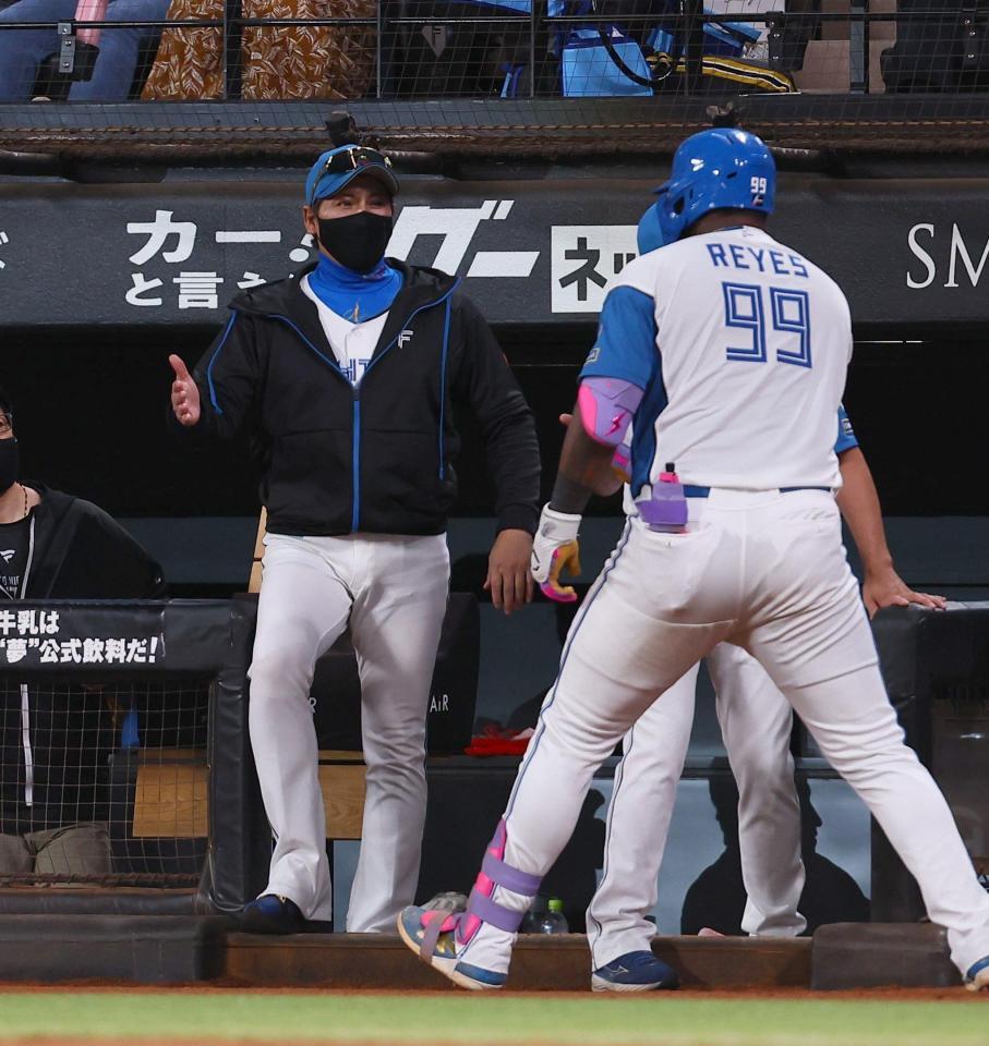 　８回、同点ソロを放ったレイエス（９９）を迎える新庄監督（撮影・中島達哉）