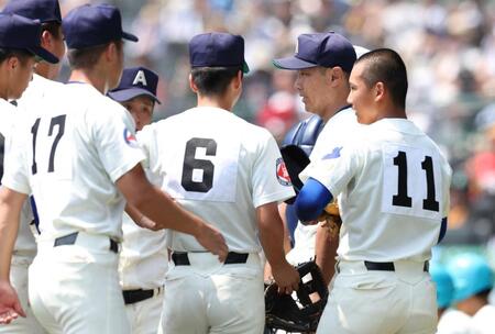 　１回表の守備を終えたナインを迎える綾羽・千代純平監督（撮影・中田匡峻）