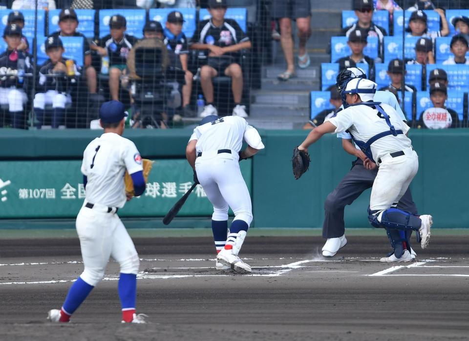 　６回、綾羽・藤田陸空（手前）から死球を受ける横浜・阿部葉太（撮影・開出牧）