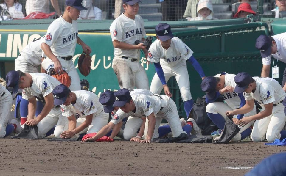　横浜に敗れ、ベンチ前で砂を集める経免（中央手前）ら綾羽ナイン