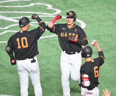 　同点ソロを放ち、中田翔（左）、坂本（右）に祝福される岡本＝２３年４月