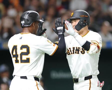 　６回、３ランを放ち、ヘルナンデス（左）とタッチを交わす坂本（撮影・西岡正）