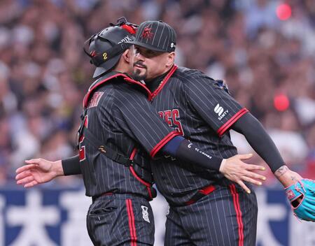 　９回表を抑え、若月（左）と抱擁を交わすマチャド（撮影・立川洋一郎）