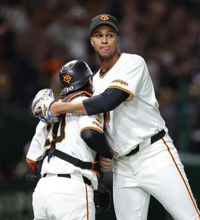 　通算２００セーブを達成し、甲斐（左）と抱き合うマルティネス（撮影・西岡正）