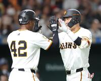 　６回、３ランを放ち、ヘルナンデス（左）とタッチを交わす坂本（撮影・西岡正）