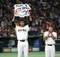 　通算２００セーブを達成し、阿部監督（右）に祝福されながらボードを掲げるマルティネス（撮影・西岡正）