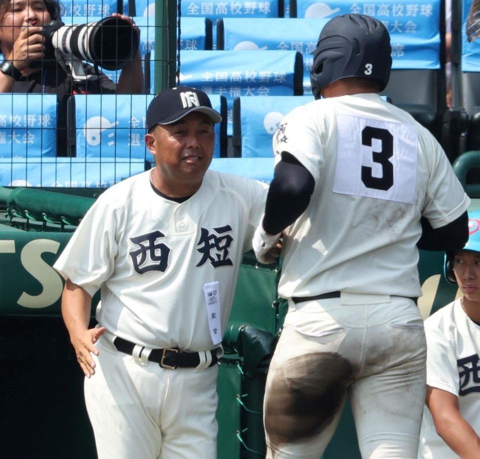 　８回、勝ち越し適時二塁打を放った佐藤仁（右）を迎える西日本短大付・西村慎太郎監督（撮影・中田匡峻）