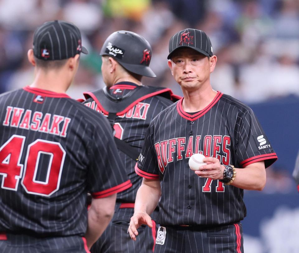 　７回、リリーフ登板する岩崎（左）にボールを手渡す岸田監督（撮影・立川洋一郎）