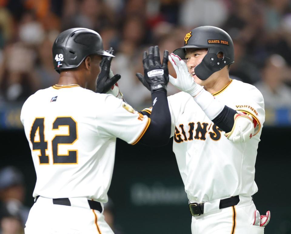 　６回、３ランを放ち、ヘルナンデス（左）とタッチを交わす坂本（撮影・西岡正）