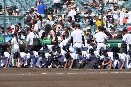 　３回戦で敗退し甲子園の土を拾う高川学園ナイン（撮影・開出牧）