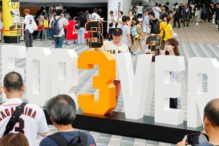 　モニュメントと記念撮影する、長嶋茂雄さんの追悼試合に訪れたファン＝１６日、東京ドーム