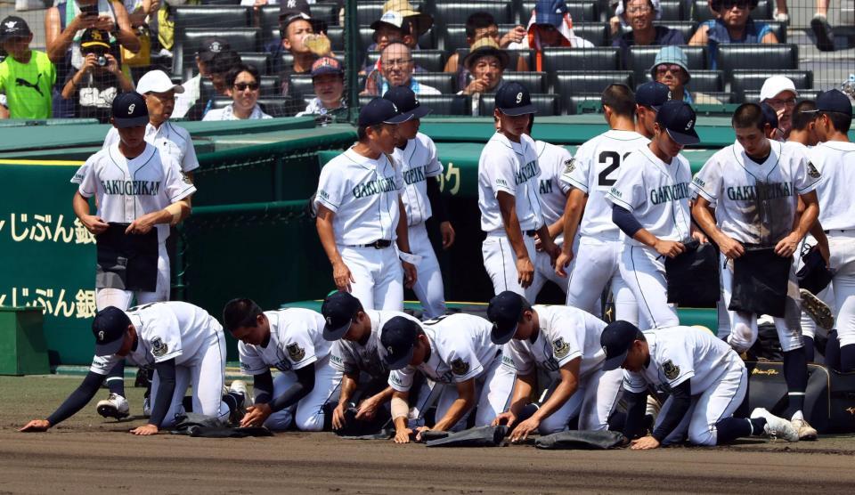 　山梨学院に敗れ、ベンチ前でグラウンドの土を集める岡山学芸館ナイン（撮影・山口登）