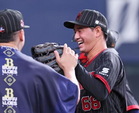 　１１回表に登板して無失点に抑えナインの出迎えに笑顔を見せる入山（撮影・立川洋一郎）