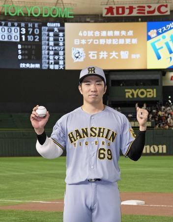 　巨人戦で４０試合連続無失点のプロ野球新記録を樹立し、ボールを手にポーズをとる阪神の石井大智投手＝１７日、東京ドーム