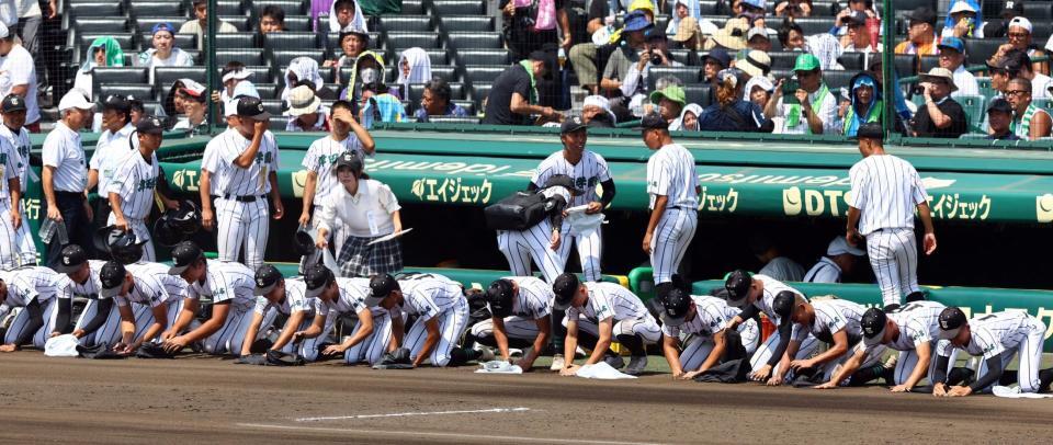 　ベンチ前でグラウンドの土を集める津田学園ナイン（撮影・山口登）
