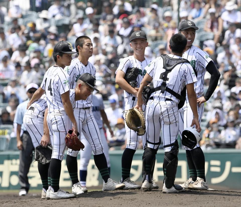 　３回、先制を許しマウンドに集まる津田学園ナイン