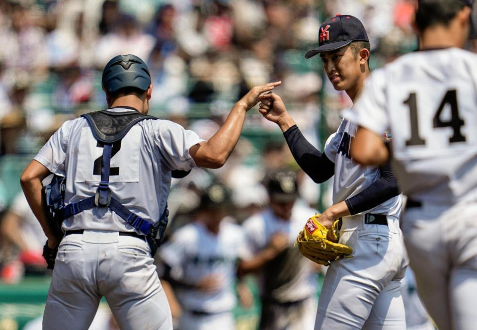 　津田学園を完封し、捕手・駒橋とタッチを交わす横浜・織田