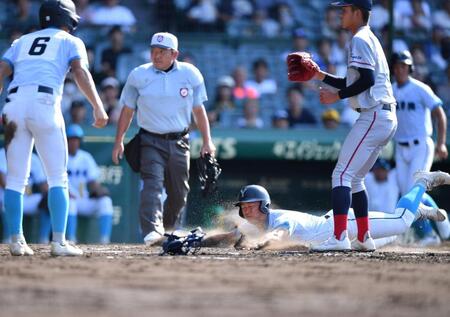 　２回、田村颯丈郎の三ゴロを清水詩太が悪送球し、二塁からホームにヘッドスライディングで生還する萬場翔太。右手前は京都国際・西村一毅（撮影・開出牧）