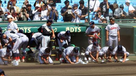 　ベンチ前でグラウンドの土を集まる京都国際ナイン（撮影・山口登）