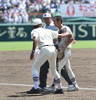 　九回表の攻撃で頭部死球を受けた日大三・松岡翼（中央）は、勝利後の整列に加われずベンチへ引き揚げる。手前は三木有造監督（撮影・開出牧）