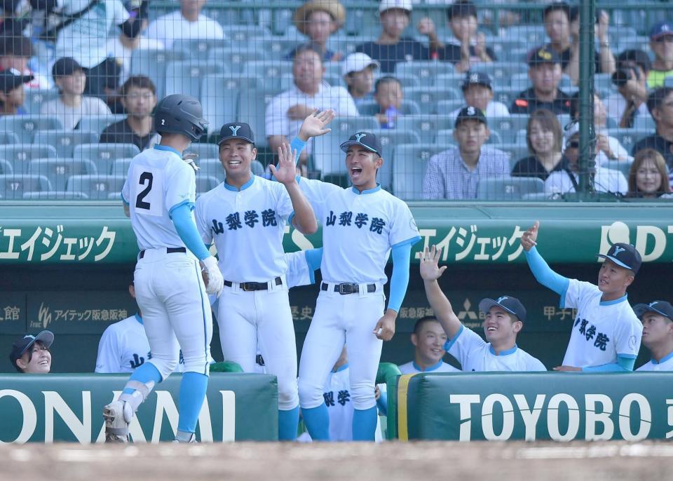 　２回、同点の左越えソロを放った横山悠（２）とタッチを交わす山梨学院ナイン（撮影・開出牧）