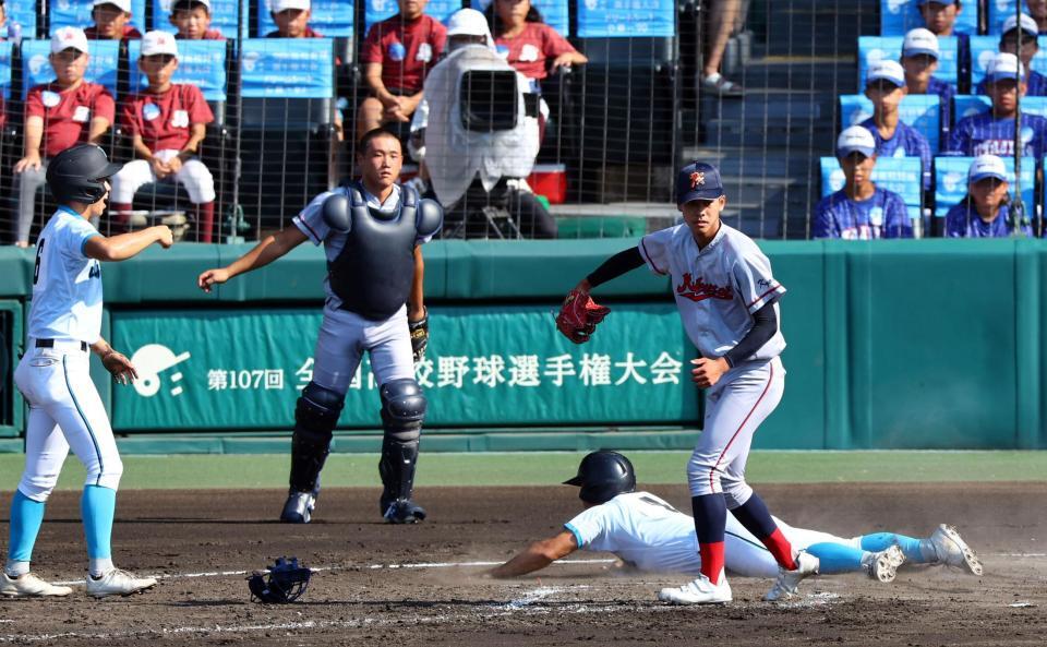 　２回、京都国際の守備が乱れ、二塁走者の山梨学院・萬場翔太も生還し２点を勝ち越す（投手　京都国際・西村一毅、捕手　京都国際・猪股琉冴）＝撮影・山口登