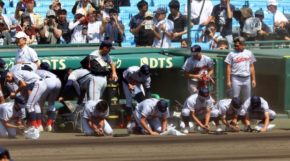 　ベンチ前でグラウンドの土を集まる京都国際ナイン（撮影・山口登）