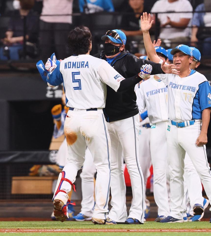 　逆転サヨナラ打を放った野村（５）と抱き合う新庄監督（中央）＝撮影・中島達哉