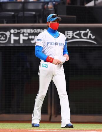 　赤いマスクでメンバー表交換に向かう新庄監督（撮影・中島達哉）
