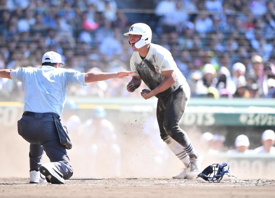 　８回、近藤優樹の中前適時打で同点のホームにヘッドスライディングで生還し雄たけびを上げる日大三・田中諒（撮影・開出牧）
