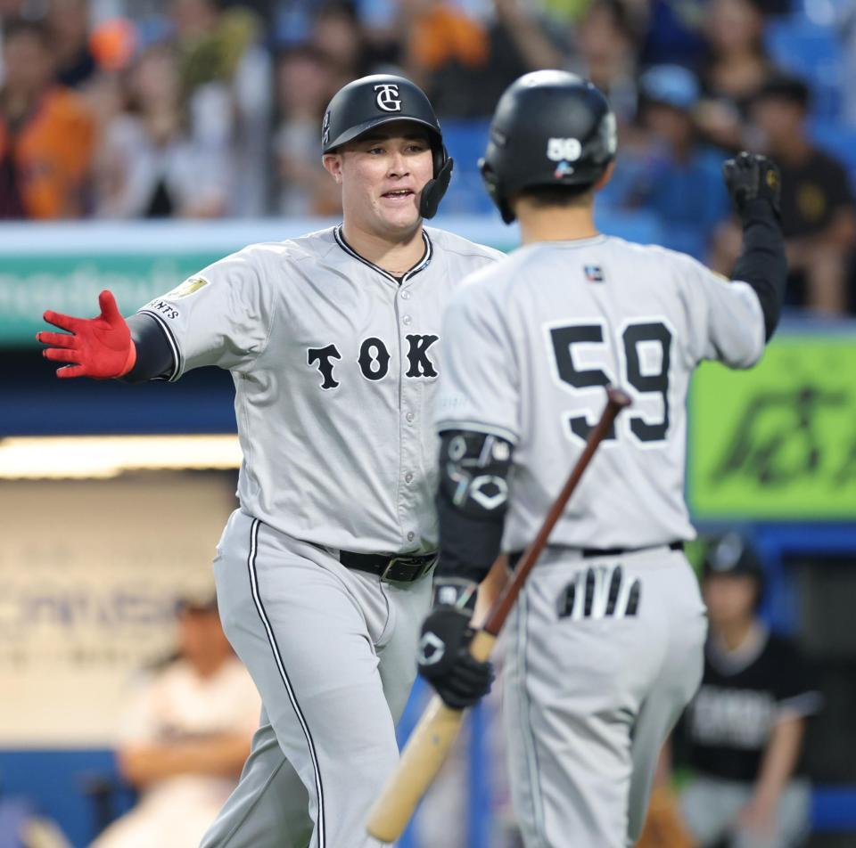 　２回、２ランを放ち、若林（右）とタッチを交わすリチャード（撮影・西岡正）