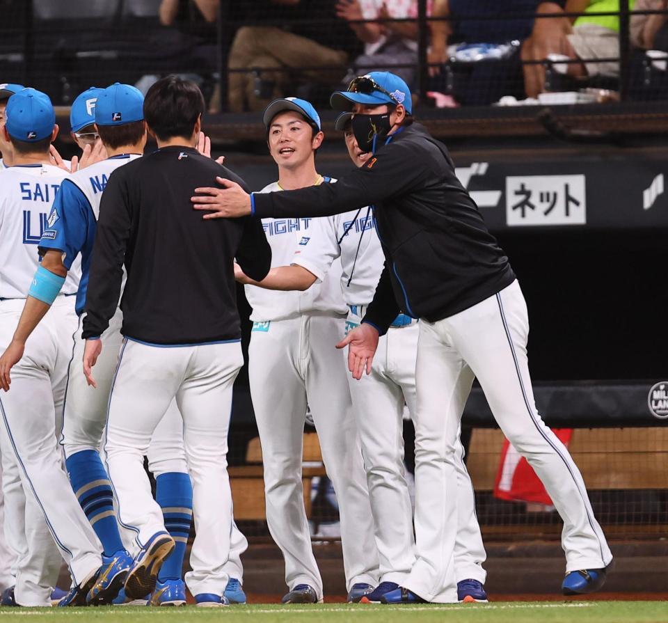 　笑顔でナインを迎える新庄監督（右）＝撮影・中島達哉