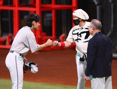 　試合前、野村（左）とグータッチを交わす新庄監督＝２２日