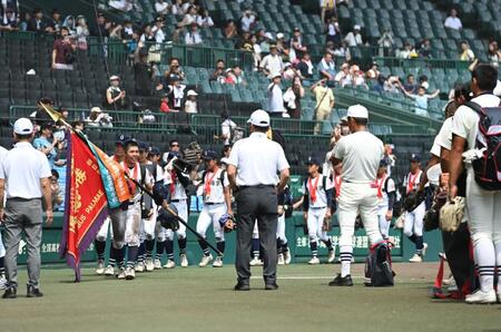 　三木有造監督（右中央）ら日大三ナインにあいさつしてグラウンドから引き揚げる真喜志拓斗ら沖縄尚学ナイン（撮影・開出牧）