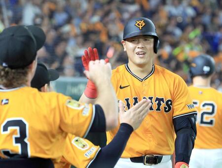 　５回、先制ソロを放ち、ナインに迎えられる岡本