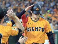 　５回、先制ソロを放ち、ナインに迎えられる岡本