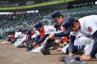 　閉会式の後、グラウンドの土を集める沖縄尚学の選手たち（代表撮影）