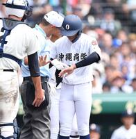 　７回、死球を受けた左手を主審に見せる沖縄尚学・伊波槙人（撮影・開出牧）