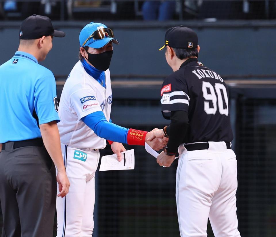 　メンバー表を交換し、小久保監督（右）と握手を交わす新庄監督（撮影・中島達哉）