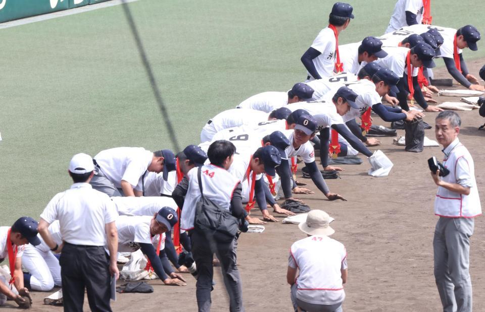 　閉会式後、砂を集める沖縄尚学ナイン（撮影・中田匡峻）