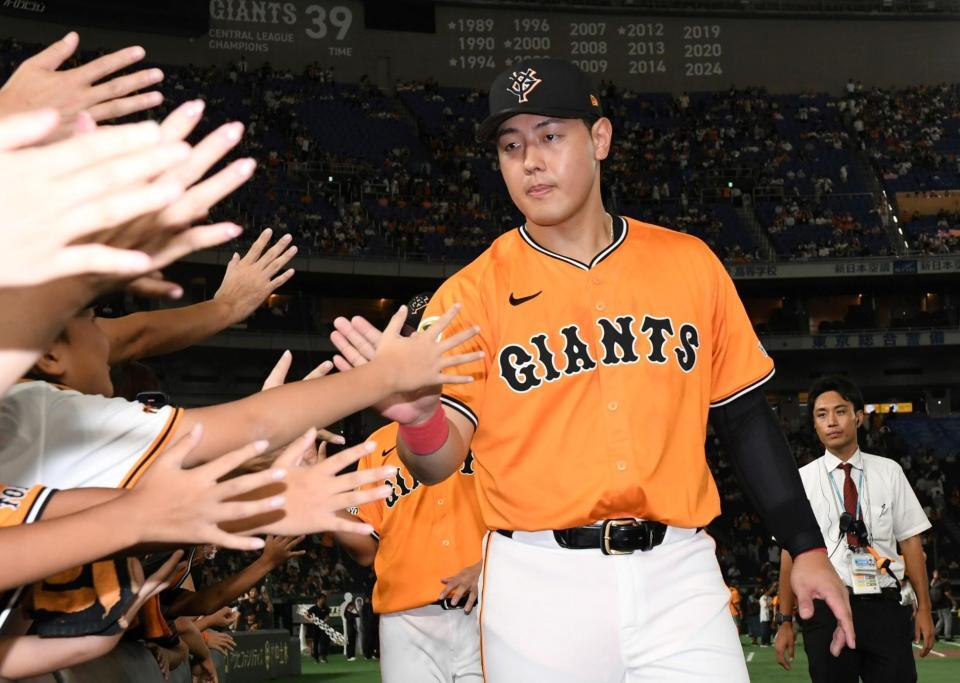 　ファンとタッチを交わす岡本（撮影・佐藤厚）